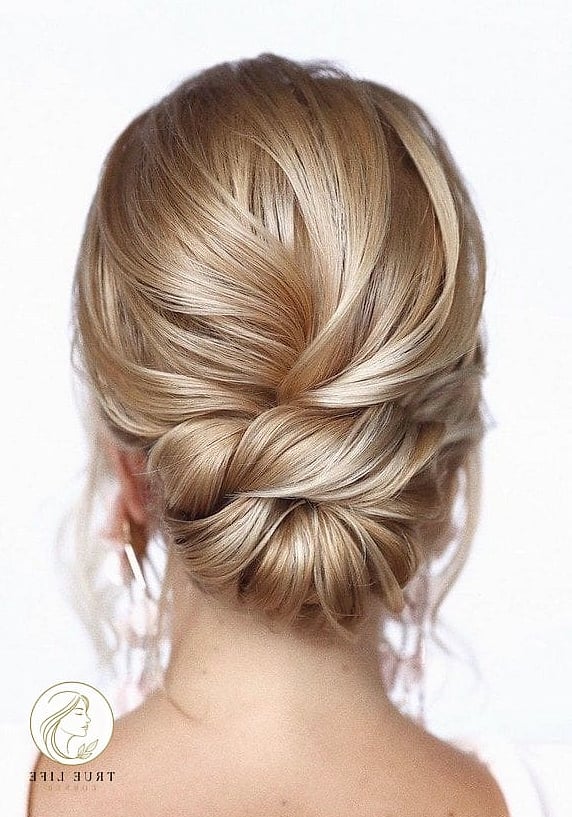 30 Bun Hairstyles For Long Hair That Belong on Your Inspiration Board 15 Bridal Low Bun with Flowers