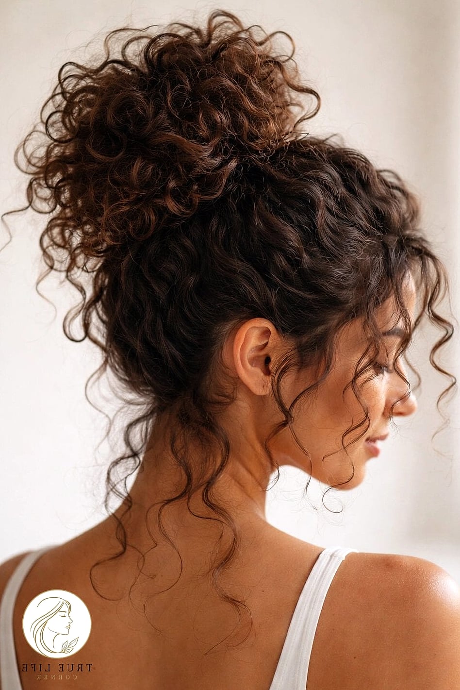 30 Bun Hairstyles For Long Hair That Belong on Your Inspiration Board 22 Voluminous Top Bun with Curls